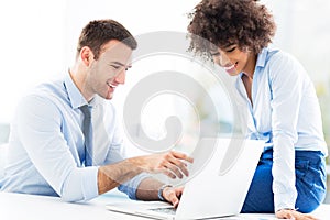 Business people looking at laptop