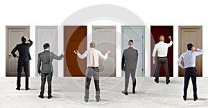 Business people looking to select the right door. Concept of confusion and competition photo