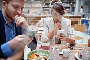 Business people  at lunch, not talking, worried, after covid, distracted from each other by cell phones. issues, recessions,