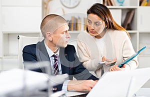 Business people man and woman discussing paperwork