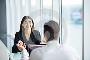 Business people man and woman Having Meeting at Table In Modern Office against panoramic windows. Focus on woman.