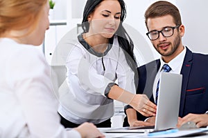 Business people at a meeting in the office. Focus on woman pointing into laptop