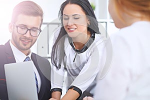 Business people at a meeting in the office. Focus on woman pointing into laptop