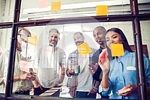 Business people meeting at office and use post it notes to share idea. Brainstorming concept. Sticky note on glass wall