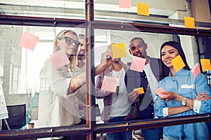 Business people meeting at office and use post it notes to share idea. Brainstorming concept. Sticky note on glass wall