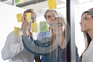 Business people meeting at office and use post it notes to share idea. Brainstorming concept. Sticky note on glass wall