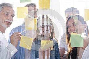 Business people meeting at office and use post it notes to share idea. Brainstorming concept. Sticky note on glass wall