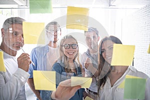 Business people meeting at office and use post it notes to share idea. Brainstorming concept. Sticky note on glass wall