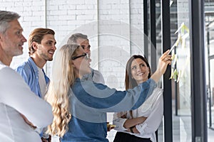 Business people meeting at office and use post it notes to share idea. Brainstorming concept. Sticky note on glass wall