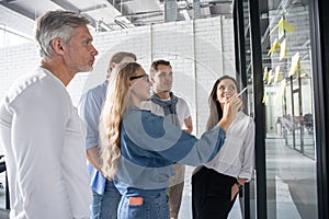 Business people meeting at office and use post it notes to share idea. Brainstorming concept. Sticky note on glass wall