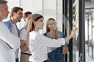 Business people meeting at office and use post it notes to share idea. Brainstorming concept. Sticky note on glass wall