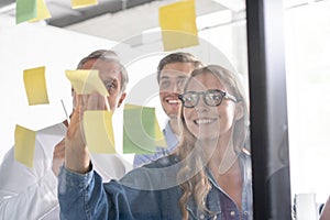 Business people meeting at office and use post it notes to share idea. Brainstorming concept. Sticky note on glass wall