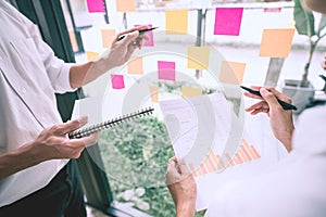 Business people meeting at office and use sticky notes on glass wall in office, diverse employees people group planning work