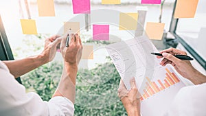 Business people meeting at office and use sticky notes on glass wall in office, diverse employees people group planning work