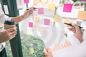 Business people meeting at office and use sticky notes on glass wall in office, diverse employees people group planning work