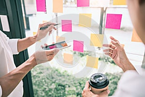 Business people meeting at office and use sticky notes on glass wall in office, diverse employees people group planning work