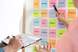 Business people meeting at office and use sticky notes on glass wall in office, diverse employees people group planning work