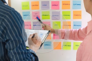 Business people meeting at office and use sticky notes on glass wall in office, diverse employees people group planning work