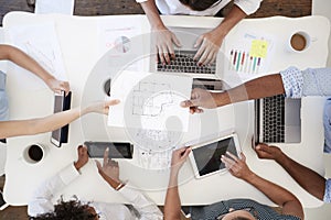 Business people at meeting passing document, overhead shot