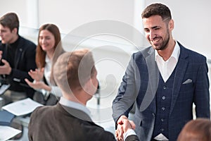 Business people during a meeting sitting around a table and appl