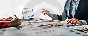 Business People Meeting using laptop computer,calculator,notebook,stock market chart paper for analysis Plans to improve