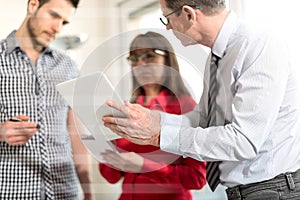 Business people in meeting working on tablet, overlayed with rays