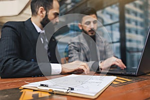 business people meets outdoors. Two men are using a laptop. Working break. Team and business support. Collaboration and