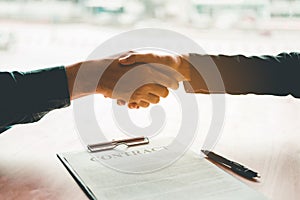 Business people negotiating a contract handshake between two col photo