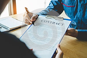 Business people negotiating a contract between two colleagues