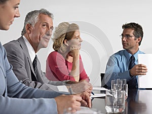 Business People With Paperwork In Conference Room