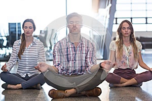 Business people performing yoga on floor