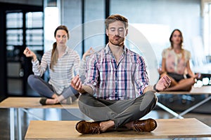 Business people performing yoga on table