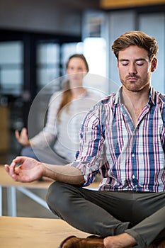 Business people performing yoga on table