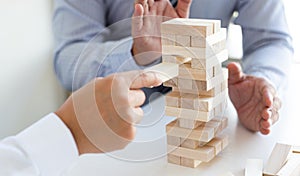 Business people play wooden games together, divide the average investment value of a business and jointly manage risks