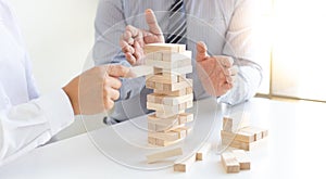 Business people play wooden games together, divide the average investment value of a business and jointly manage risks