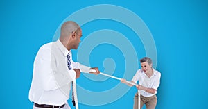 Business people playing tug of war over blue background