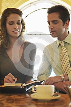 Business People Preparing Schedule At Cafe