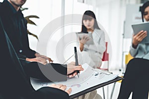 Business people proficiently discuss work project while sitting in circle