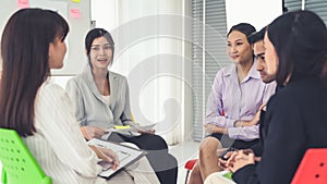 Business people proficiently discuss work project while sitting in circle