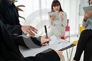 Business people proficiently discuss work project while sitting in circle