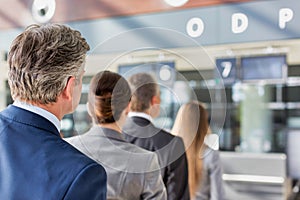 Business people queueing for check in at airport photo