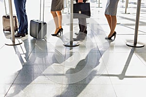 Business people queueing for check in at airport photo