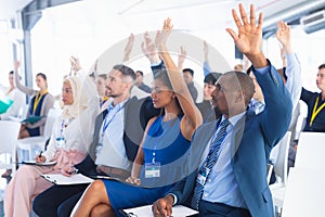 Business people raising their hands while attending business seminar