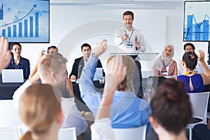 Business people raising their hands in business seminar