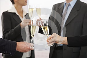 Business people raising toast with champagne