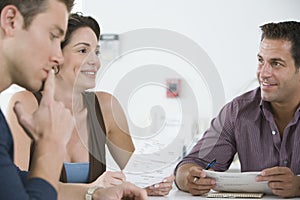 Business People Reviewing Documents In Meeting