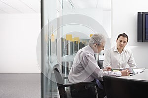 Business People Reviewing Documents At Table