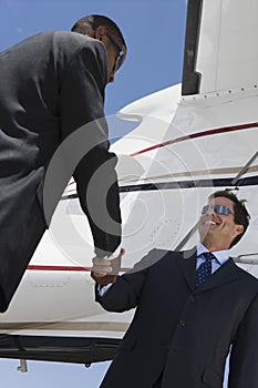 Business People Shaking Hands At Airfield photo