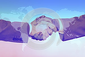 Business people shaking hands as symbol for partnership over world map background. Globalize concept photo