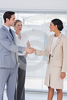 Business people shaking hands in bright office